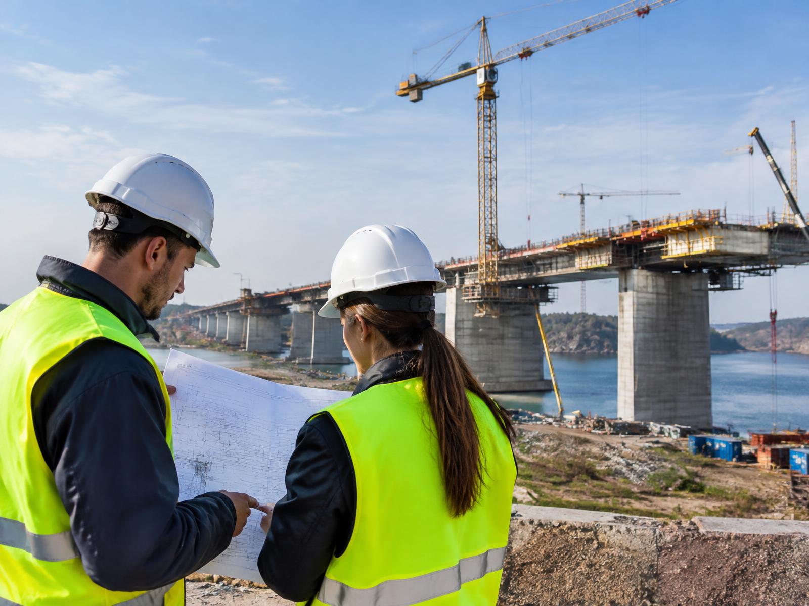 Engineers reviewing drawings on a bridge construction site